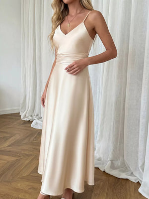 Champagne satin V-neck maxi dress with spaghetti straps and a-line skirt.