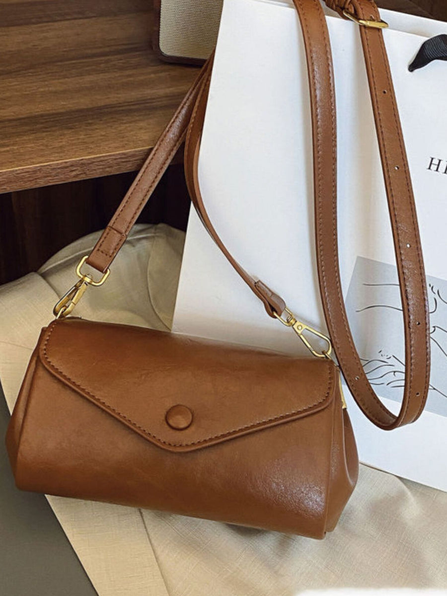Mini pu leather flap crossbody bag in light brown with button closure and gold hardware.