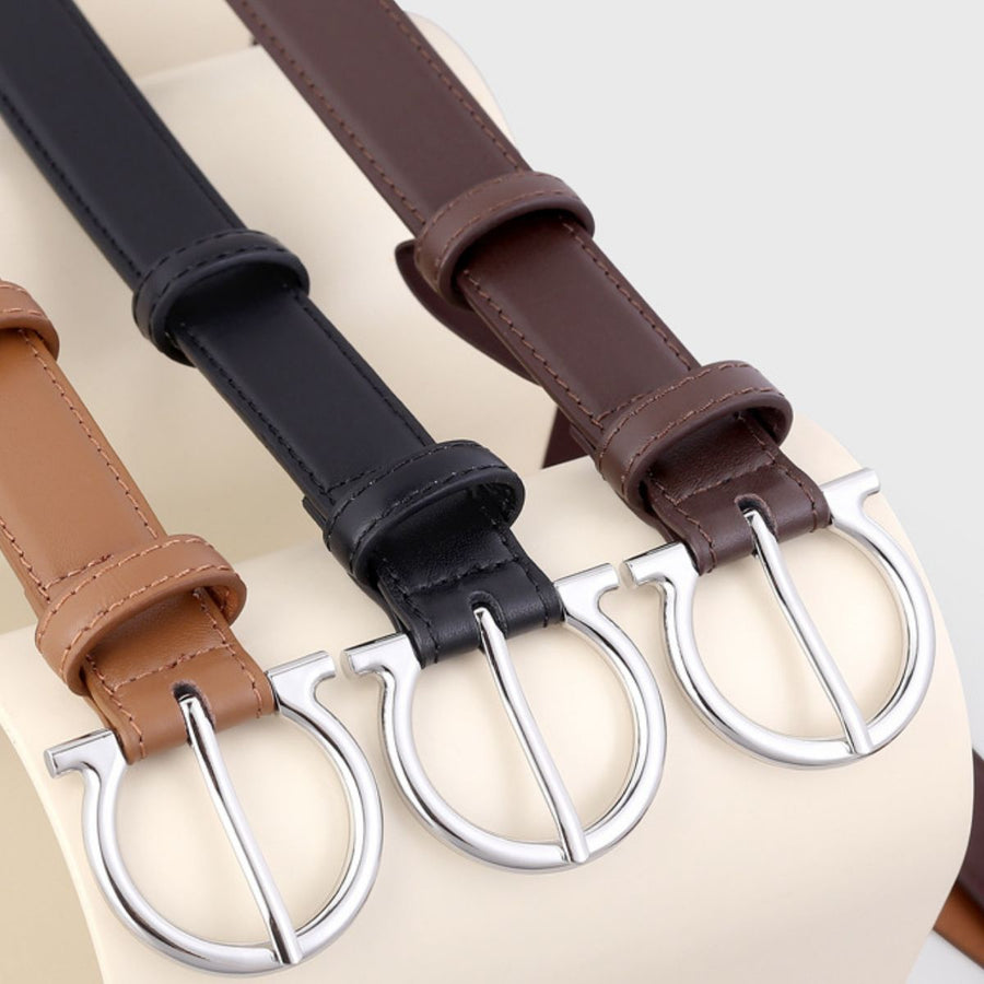 Cowhide leather belts in black, brown, and coffee brown with silver Omega buckles.