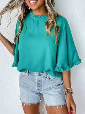 Teal ruffled mock neck half sleeve shirt with ruffled cuffs.