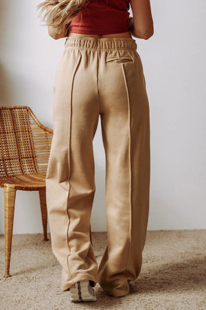 Tan wide-leg sweatpants with relaxed seam detail and elastic waistband.