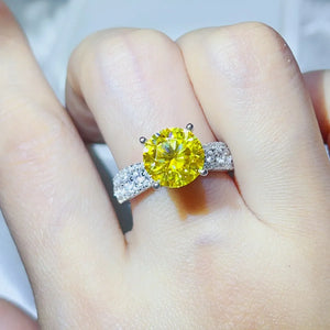 Yellow moissanite ring with pavé band on finger