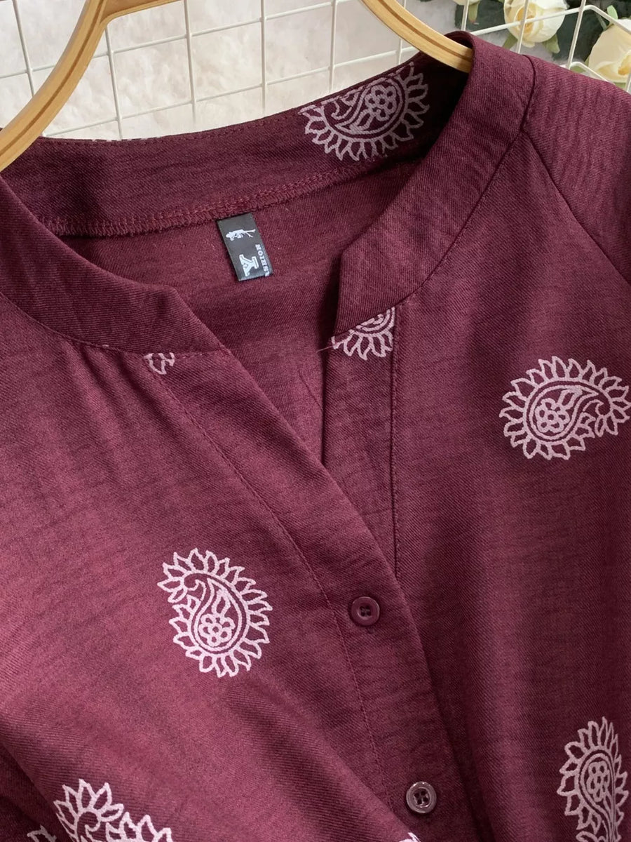 Burgundy paisley print drawstring jumpsuit with button detail and notched collar.
