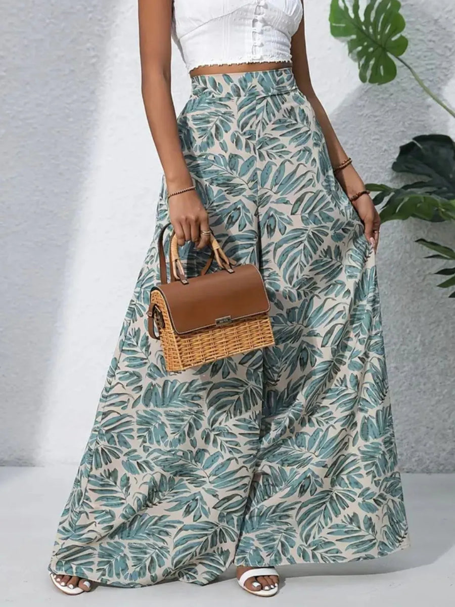 Palazzo trousers in green tropical leaf print, 100% polyester, with a wide leg cut.