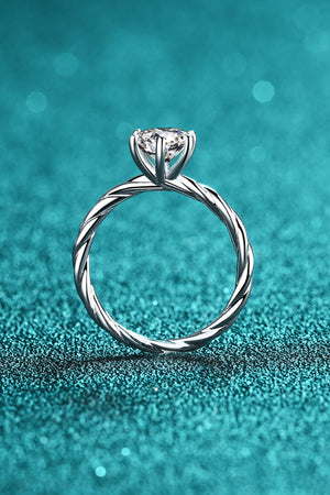 Silver twisted band moissanite solitaire ring with a six-prong setting.