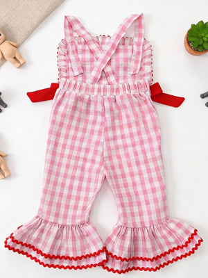Blush pink gingham cotton jumpsuit with ruffled bell bottoms and red trim.