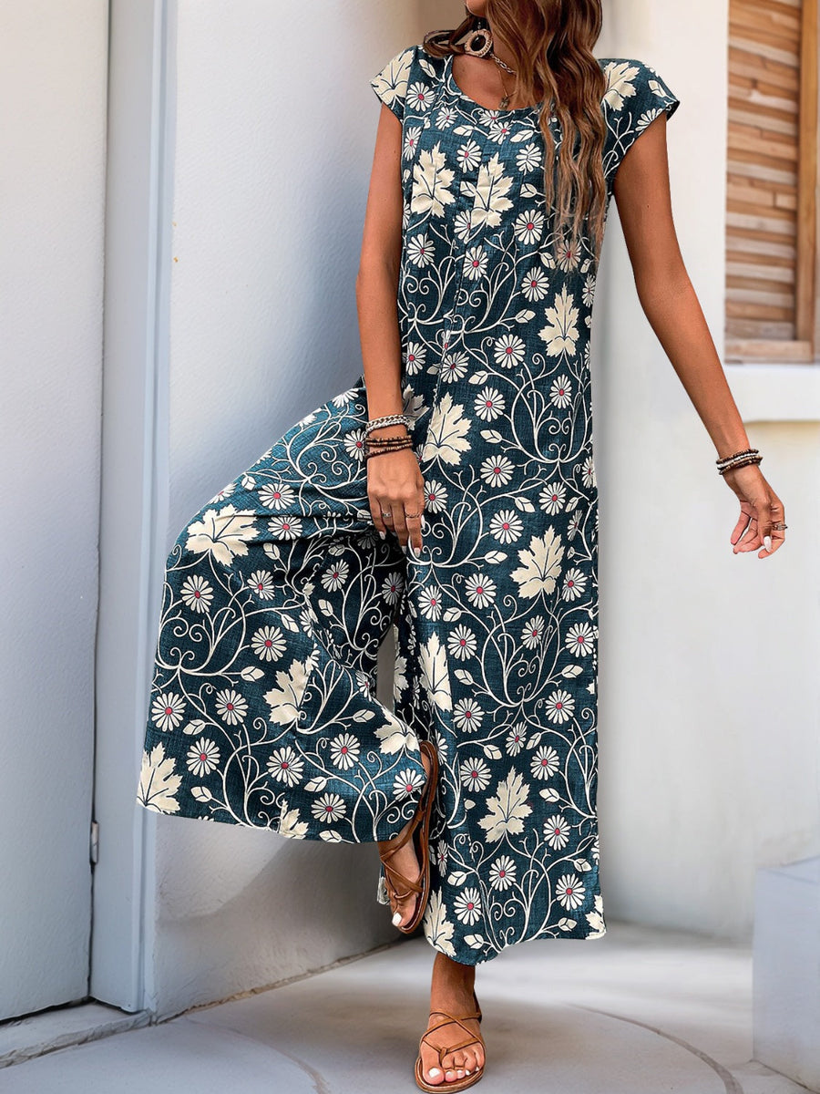 Botanical print culotte jumpsuit in dark green with short sleeves and wide legs.