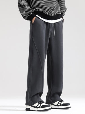 Men's grey wide-leg sweatpants with drawstring and seam detail.