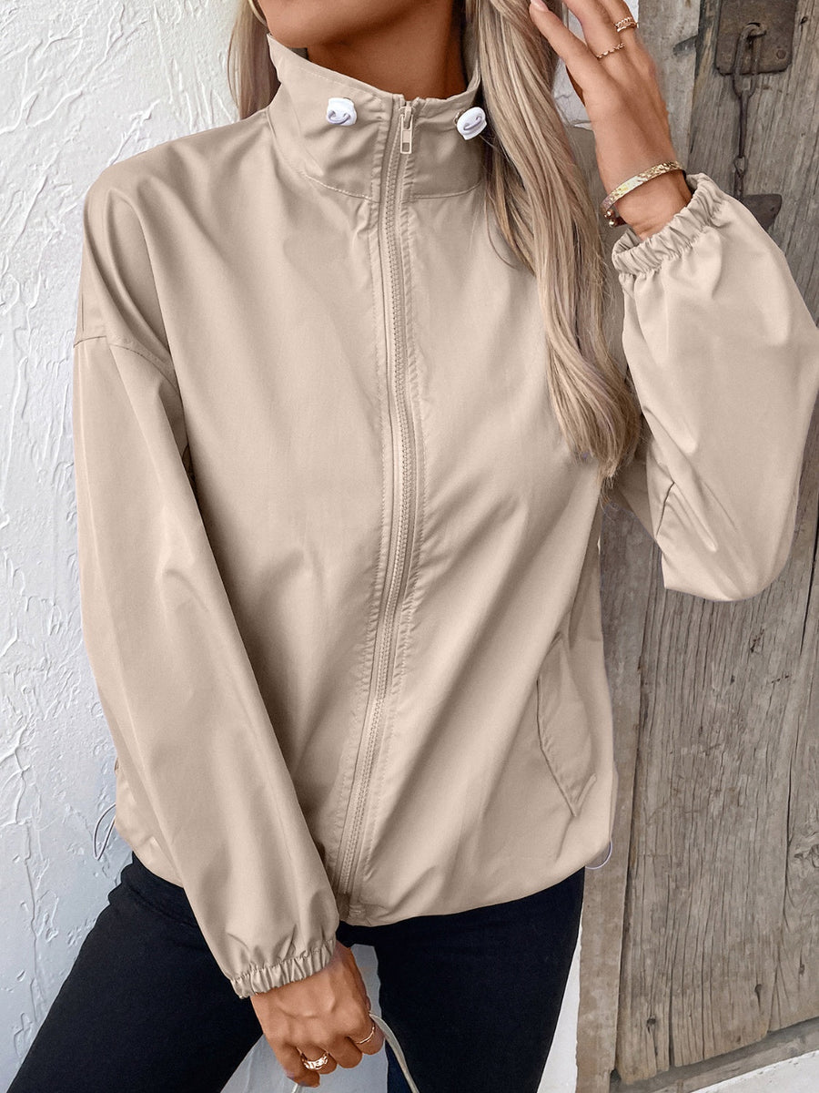 Nylon bomber jacket in beige with a drawstring hem and zippered front.