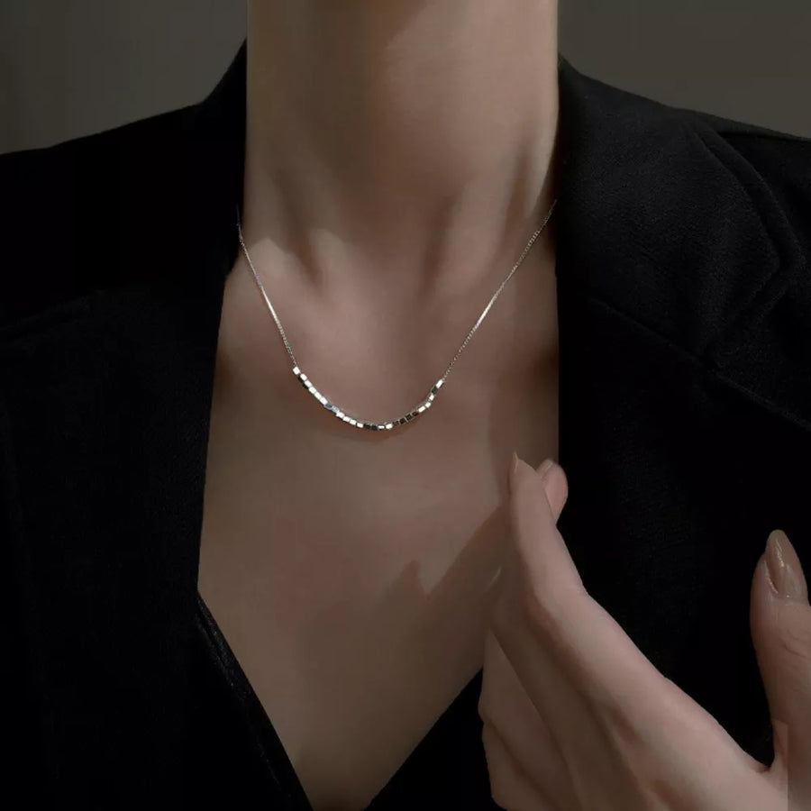 Silver necklace featuring cube beads and geometric