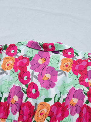 Floral v-neck midi dress in cotton with a vibrant pink, purple, and orange floral print and a pointed collar.