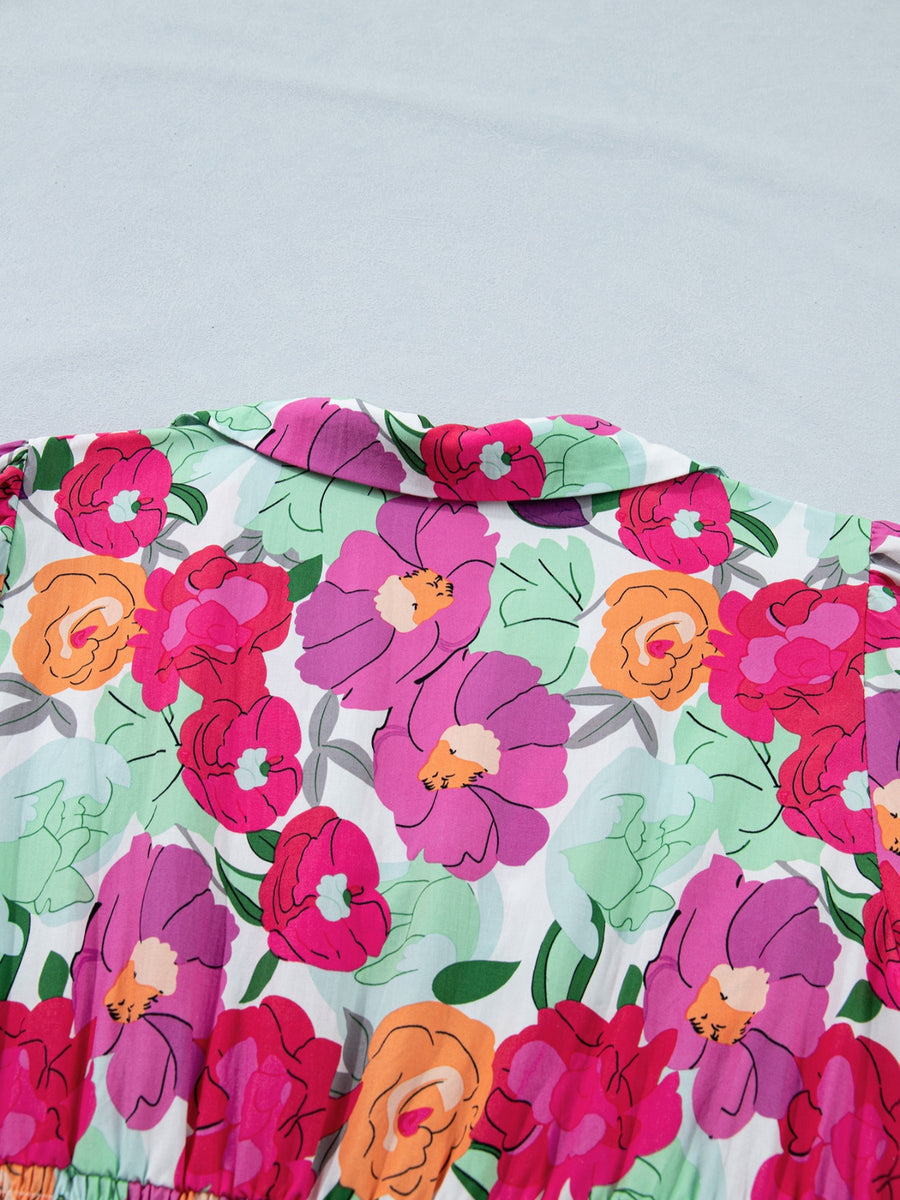 Floral v-neck midi dress in cotton with a vibrant pink, purple, and orange floral print and a pointed collar.