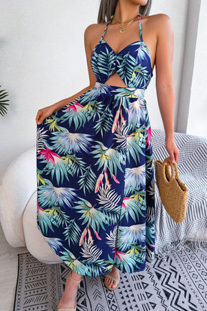 Tropical halter cutout maxi dress in dark blue with botanical print, featuring a twist front and thigh-high slit.