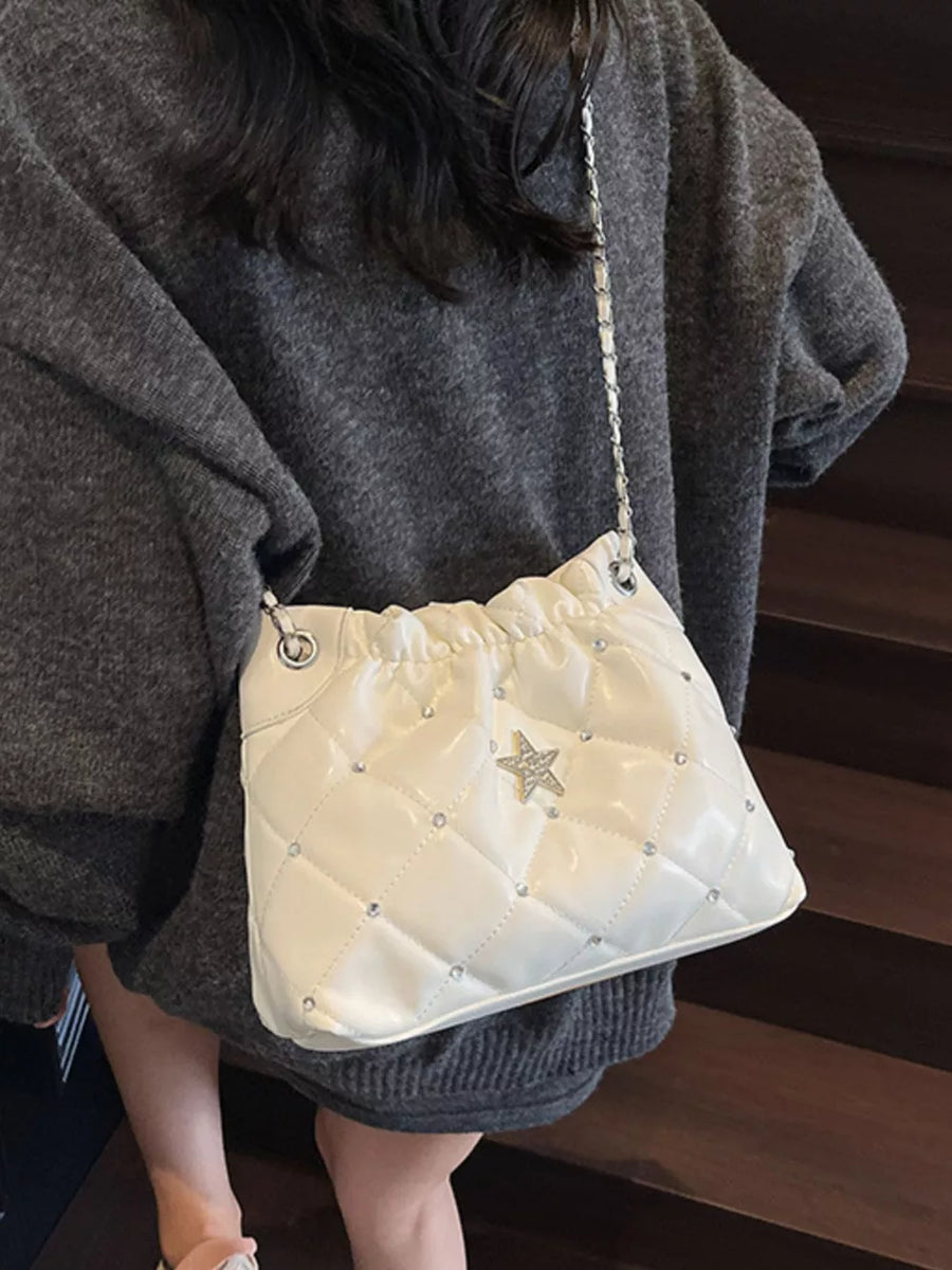 White quilted shoulder bag with diamond pattern, rhinestone accents, and a star detail.