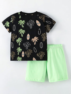 Boys' black cotton tee with tropical palm tree print and light green shorts.