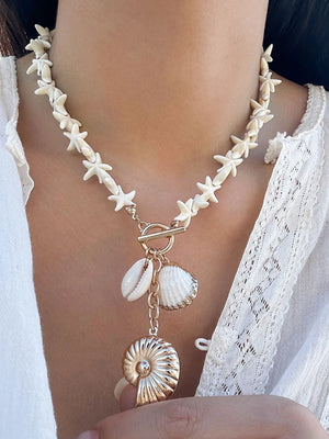 gold necklace featuring pendant and sea-life motif