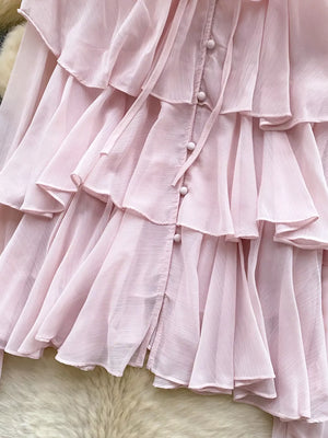 Pink chiffon blouse with tiered ruffles, button front, and bow tie detail.
