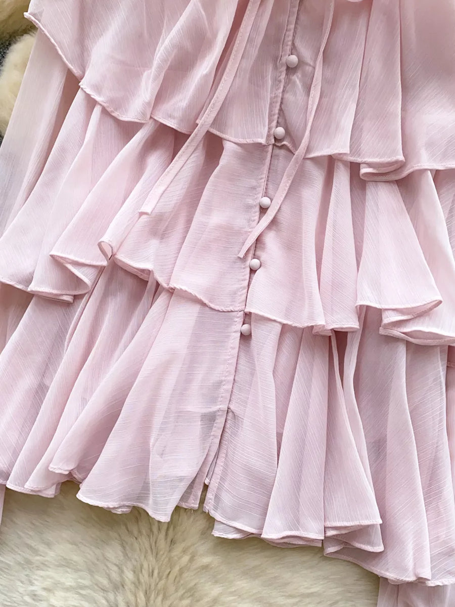Pink chiffon blouse with tiered ruffles, button front, and bow tie detail.