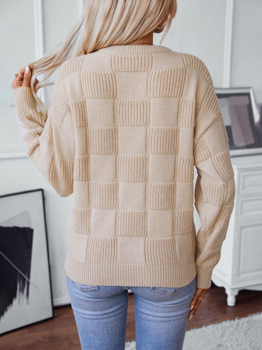 Cream textured checkerboard knit pullover sweater with ribbed details.