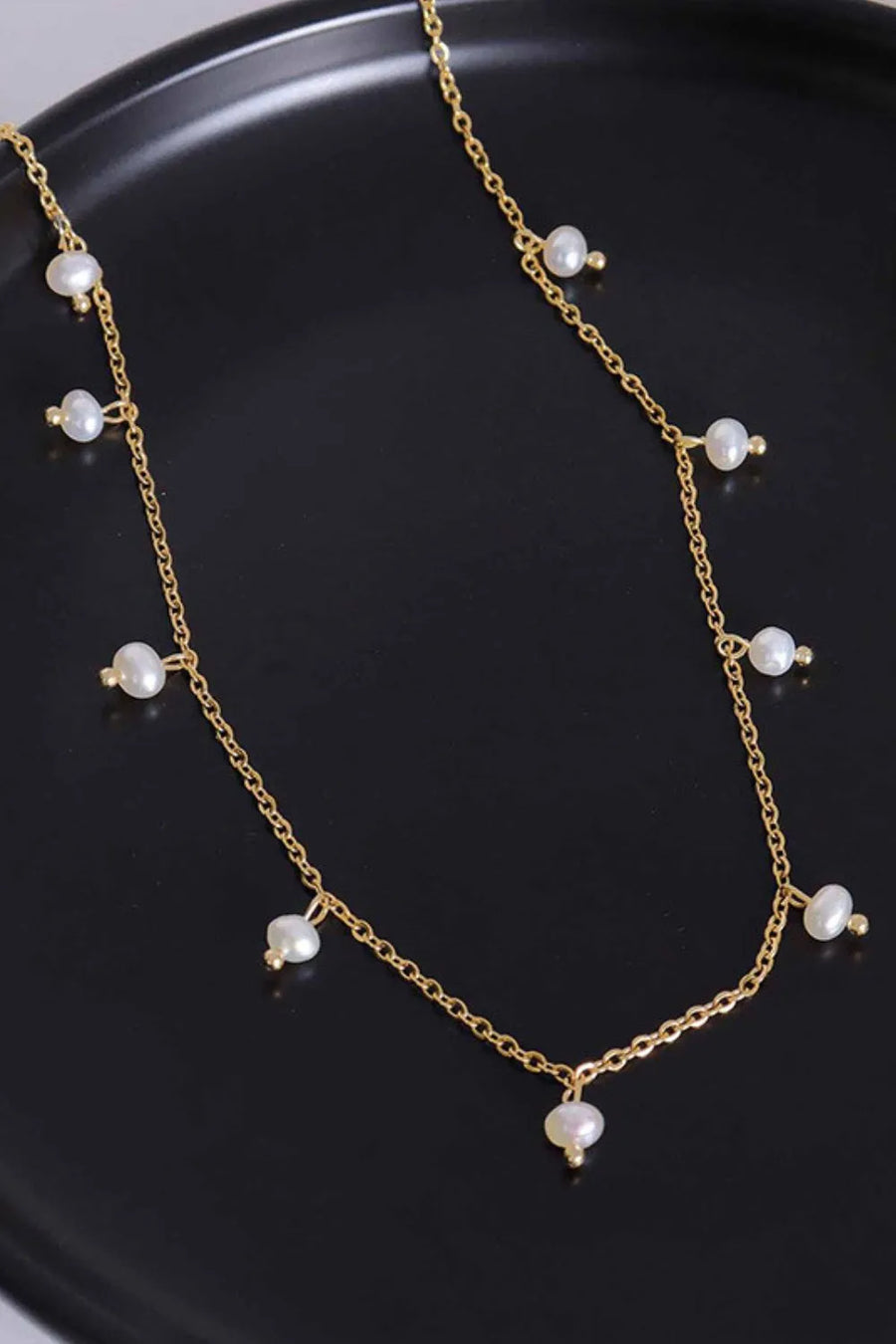 Gold chain necklace with dangling pearl accents