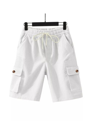 White corduroy cargo shorts with drawstring waist and button-flap pockets.