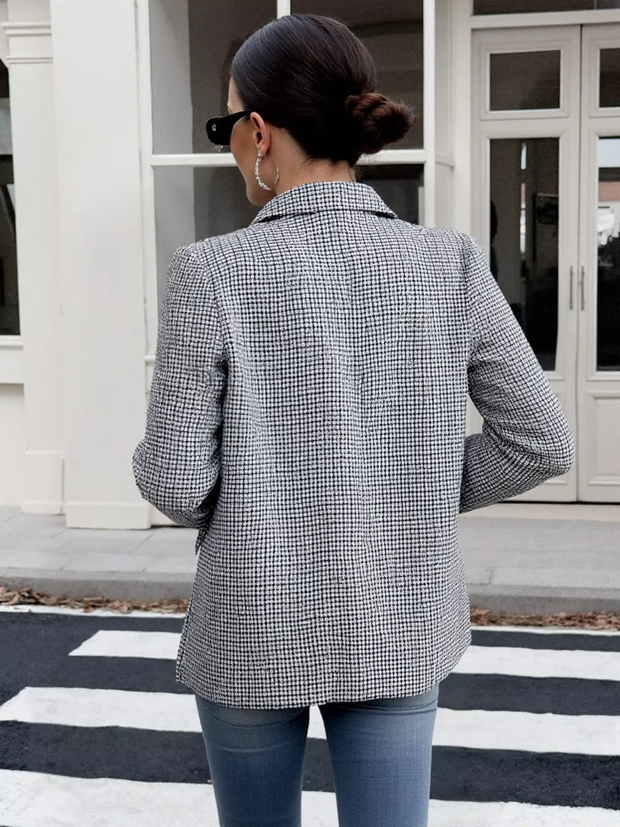 Houndstooth double-breasted blazer in black and white with a classic collar and buttoned front.