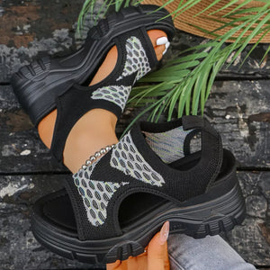 Black open-toe platform sandals with geometric pattern knit fabric and chunky sole.