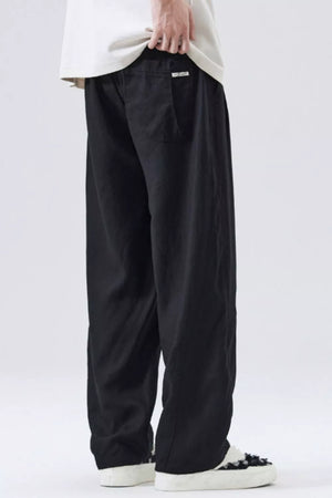 Black drawstring casual pants with a loose fit and a back pocket detail.