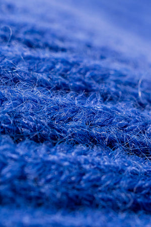 Blue chunky ribbed knit beanie detail showing acrylic texture.