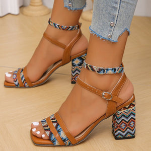 Brown geometric patterned open-toe block heels with ankle straps.