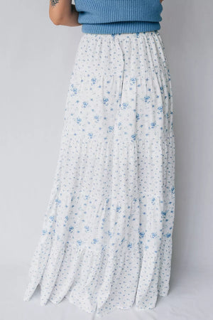 Bohemian tiered maxi skirt with blue floral print on white fabric.