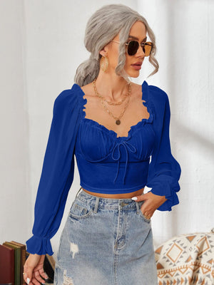 Royal Blue bustier blouse with sweetheart neckline, tie front, and ruffled long sleeves.