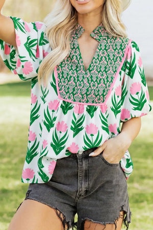 White polyester blouse with pink floral print, green trim, and puff sleeves.