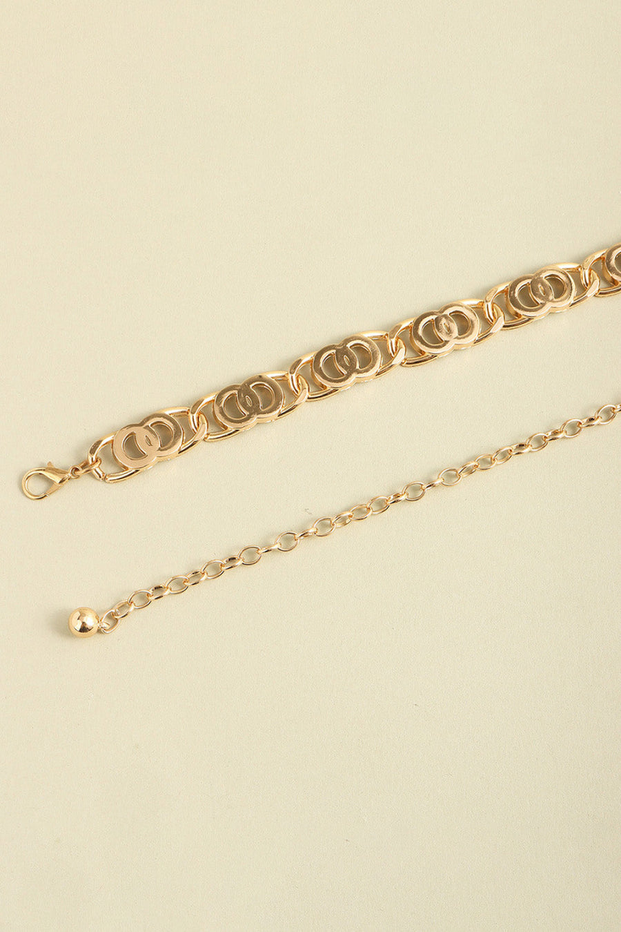Golden chain belt with interlocking circle links and adjustable extender chain.