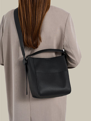 crossbody bag in black featuring textured and bucket fit