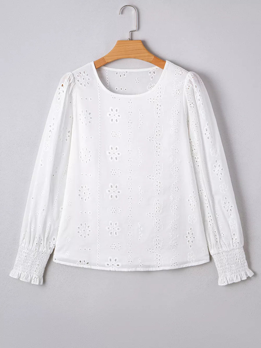 White cotton blouse with eyelet embroidery, ruffled cuffs, and puff sleeves.
