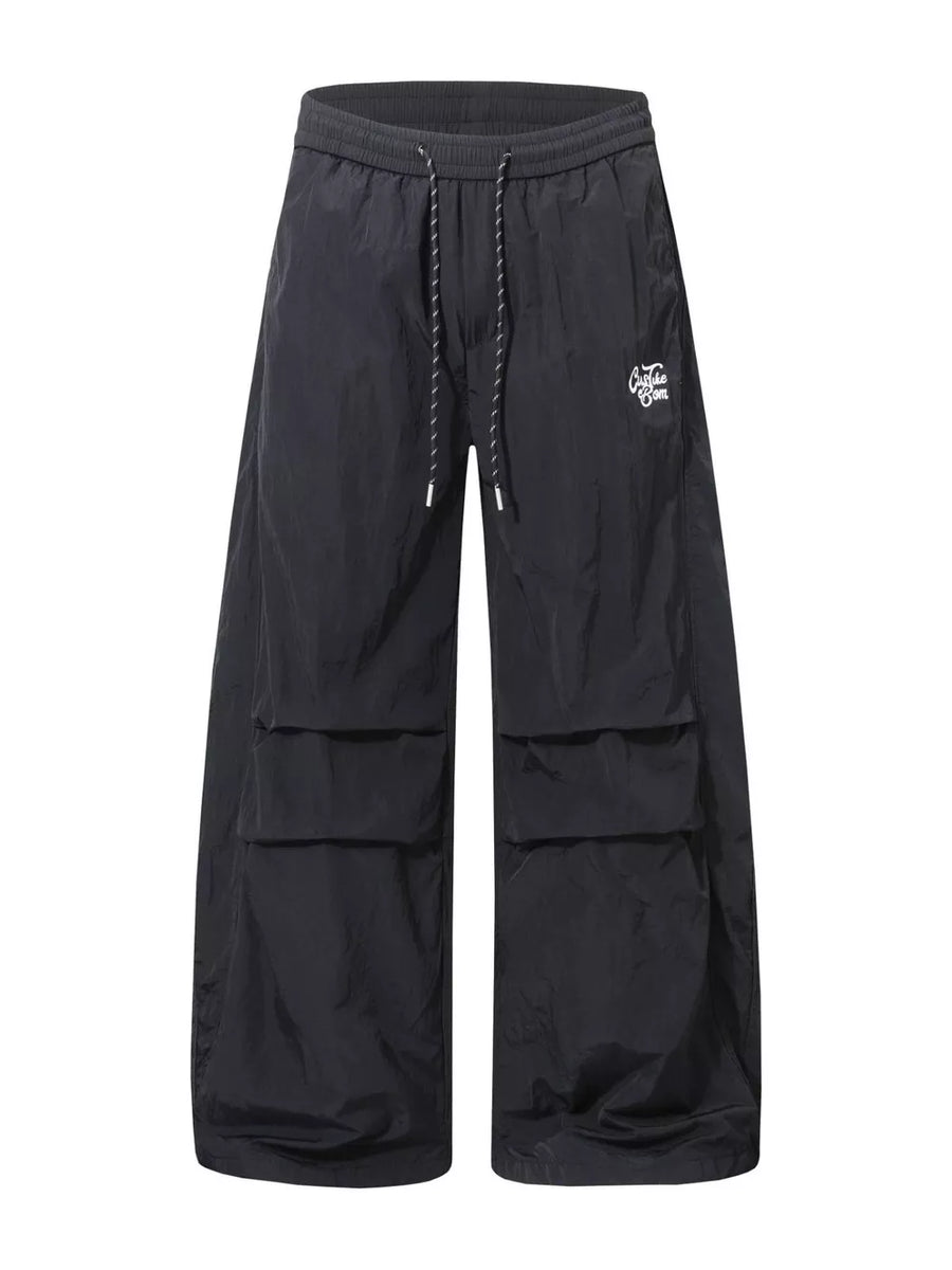Black wide-leg cargo pants with drawstring waist and large side pockets.