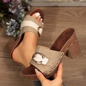 Platform mule sandals in khaki with white strap, buckle, and studded detail.