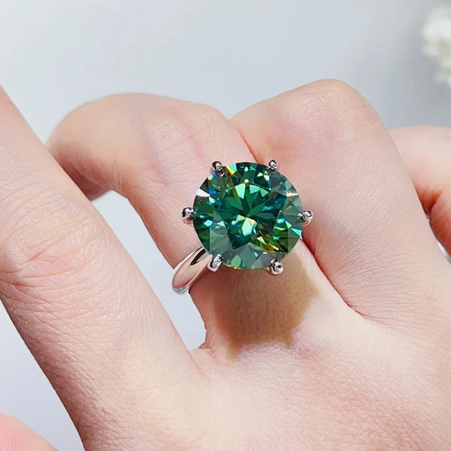 Green emerald cut moissanite solitaire ring on a sterling silver band.