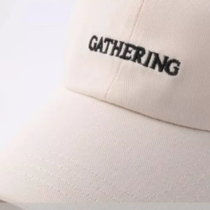 Beige cotton baseball cap with embroidered "GATHERING" text