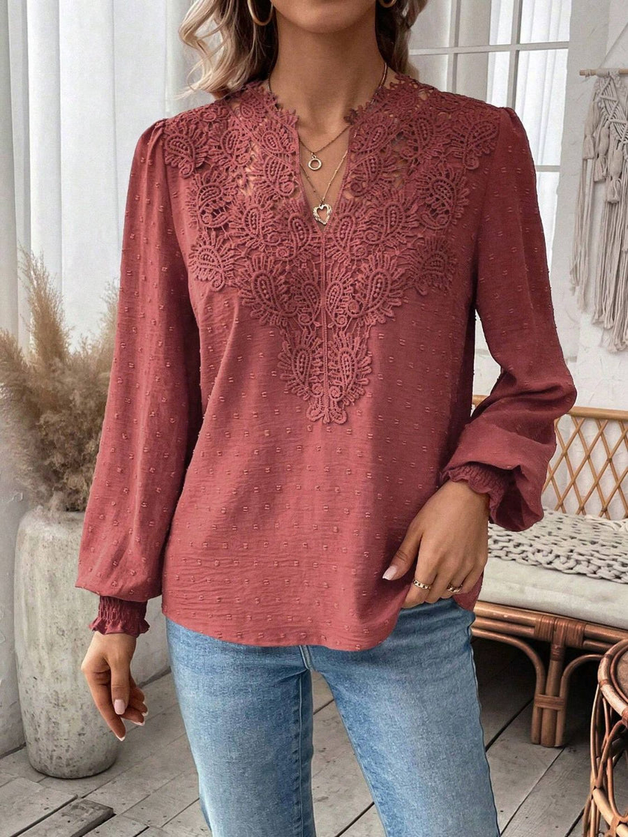 Embroidered yoke blouse in rust with puff sleeves and textured fabric.