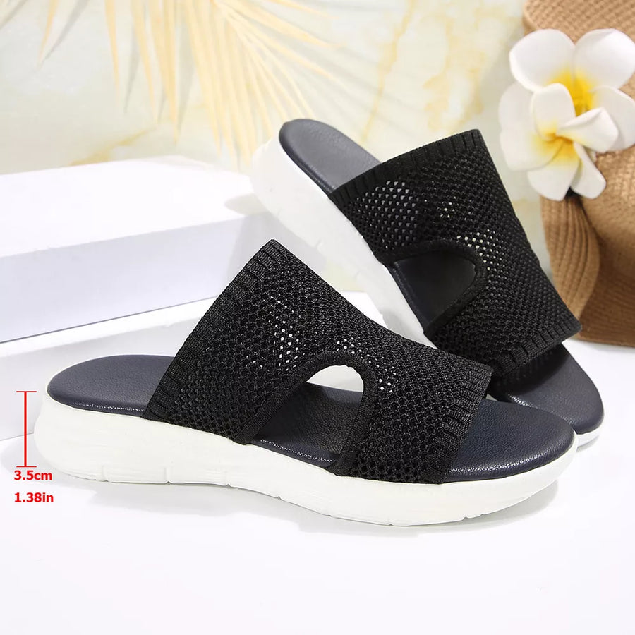 Black open-toe mesh sandals with a white sole and comfortable cushioned footbed.