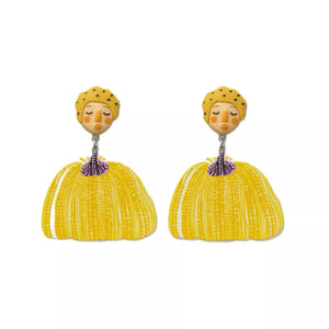 Yellow whimsical pumpkin girl dangle earrings with dotted hats and textured skirts.