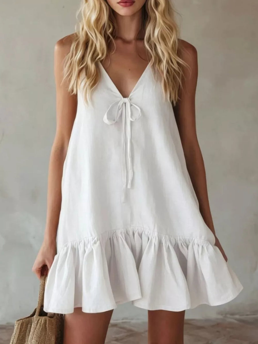 White tie-front mini dress with ruffle hem and V-neckline.