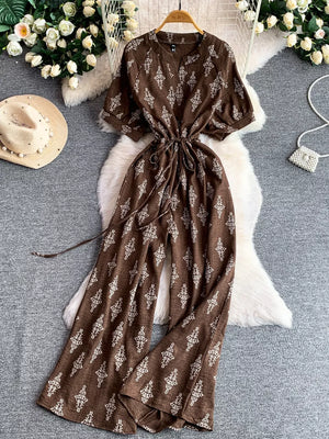 Brown patterned drawstring jumpsuit with short sleeves and wide legs.