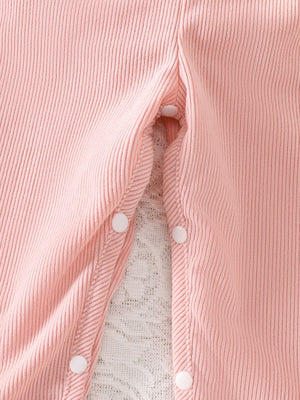 Pink corduroy baby one-piece with snap closures and lace trim detail.