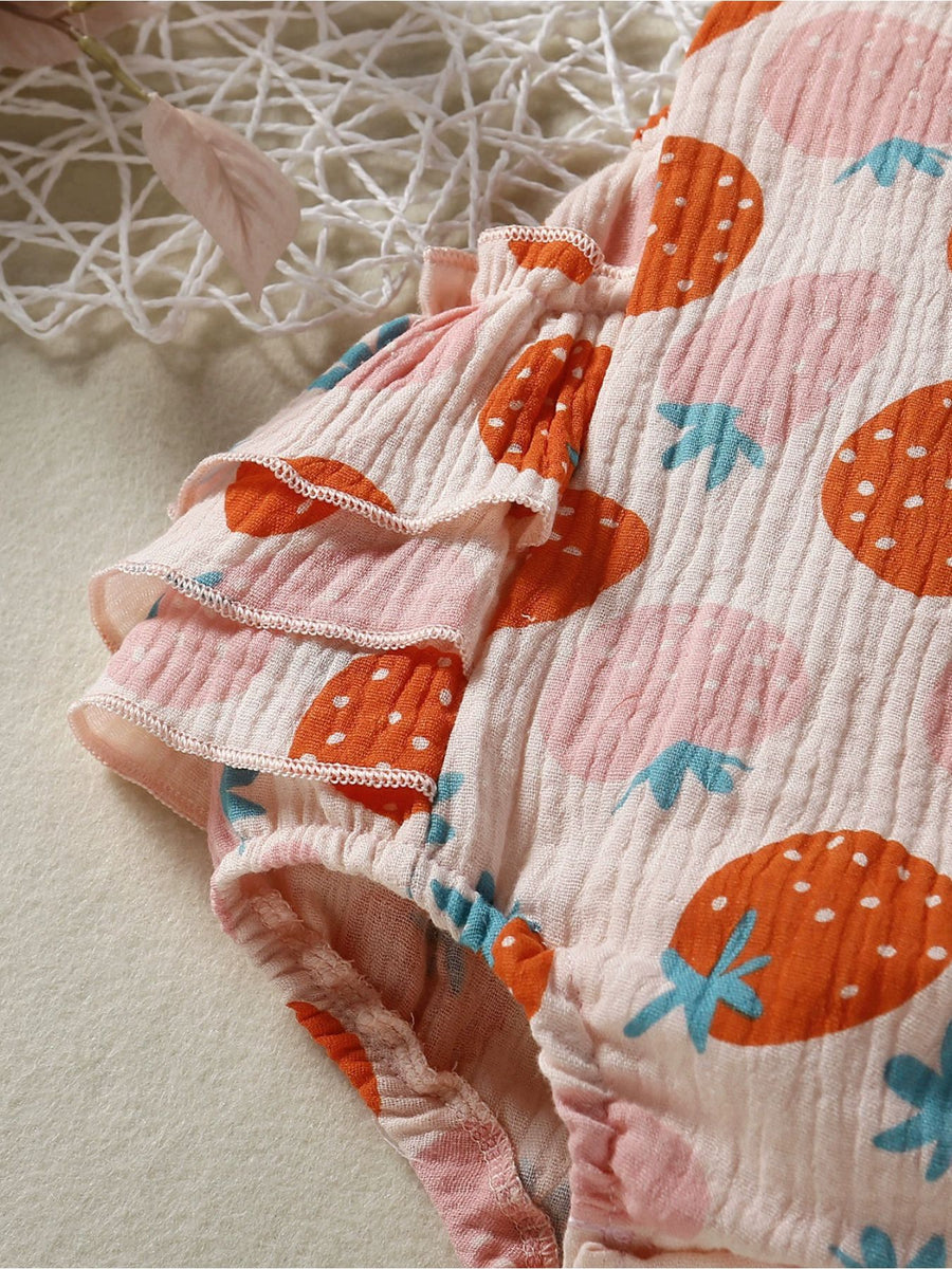 Baby bodysuit with tiered ruffle sleeves and a pink strawberry print on textured fabric.