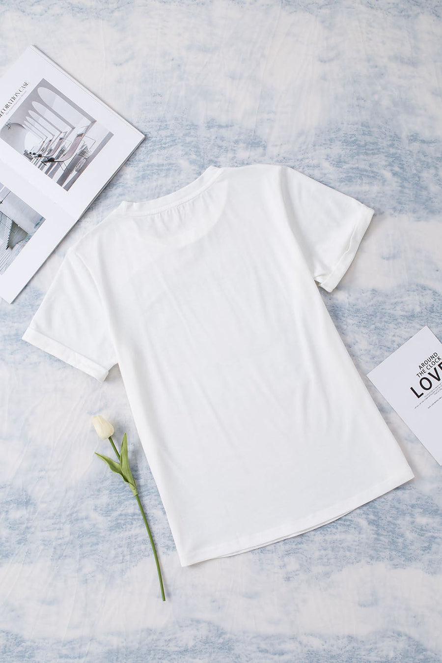 White graphic t-shirt with floral accents and short sleeves.