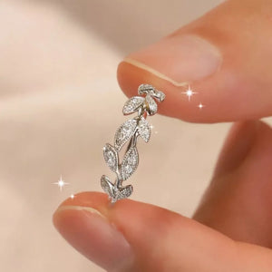 Delicate sterling silver ring with a repeating leaf design and sparkling stones.