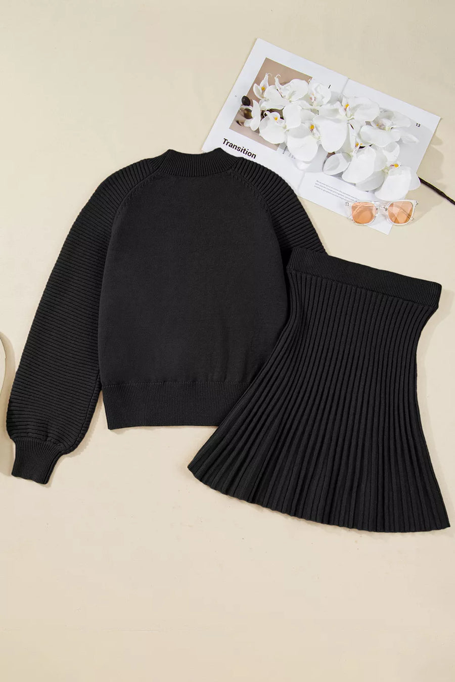 Black knit sweater set with balloon sleeves and a pleated skirt